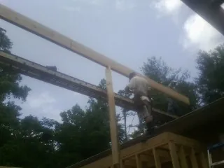 Carpenter setting a ridge beam over a new addition frame — Ice Dam Removal by Roofing Brothers in Berkeley Springs