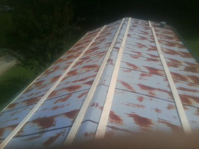 Rusted metal roof panels with new wood purlins before replacement — Storm Damage Roof Repair in Berkeley Springs by Roofing Brothers