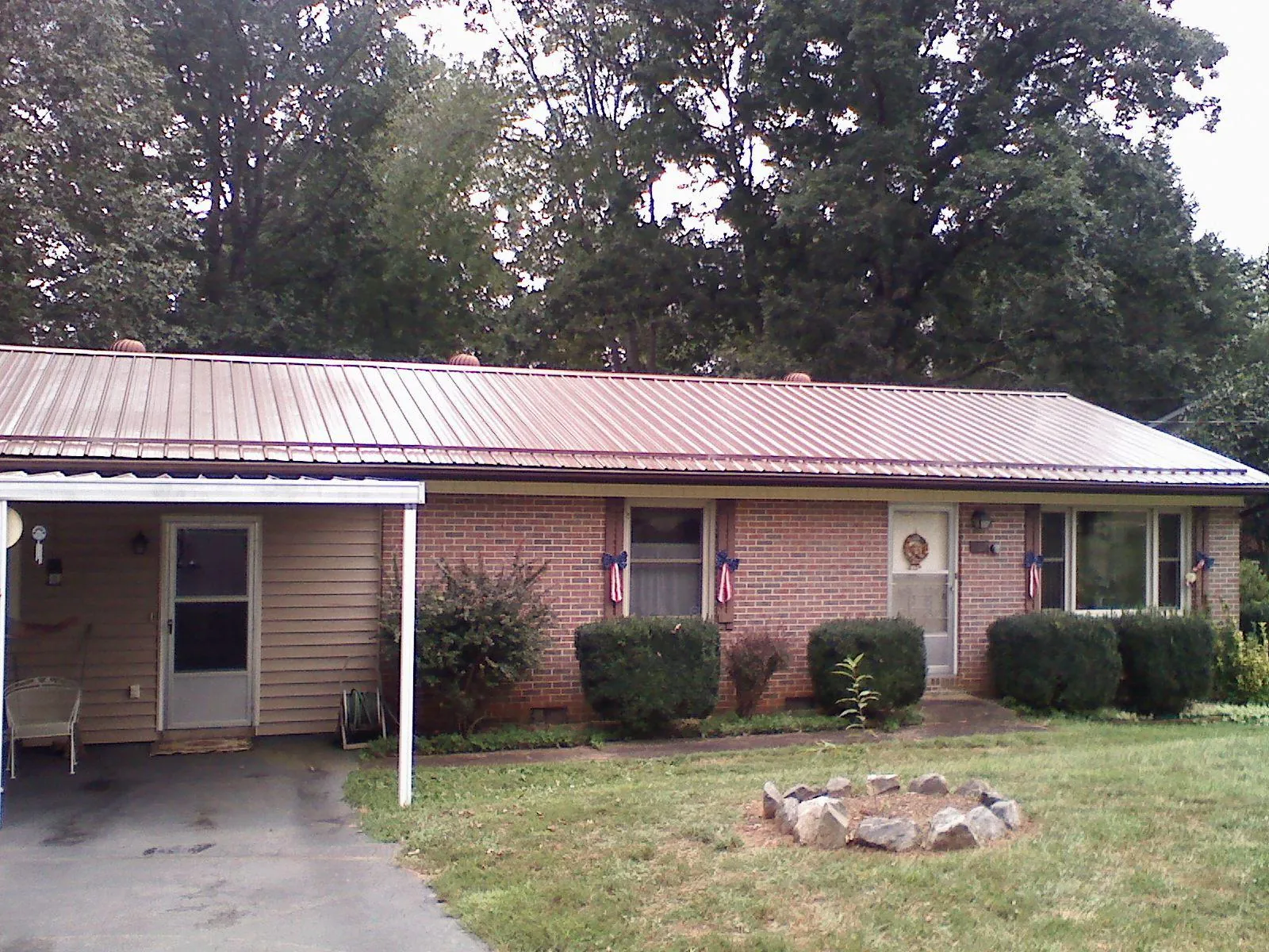 Bronze metal roof and carport on a brick ranch home — Roof Repair work by our crew in Berkeley Springs